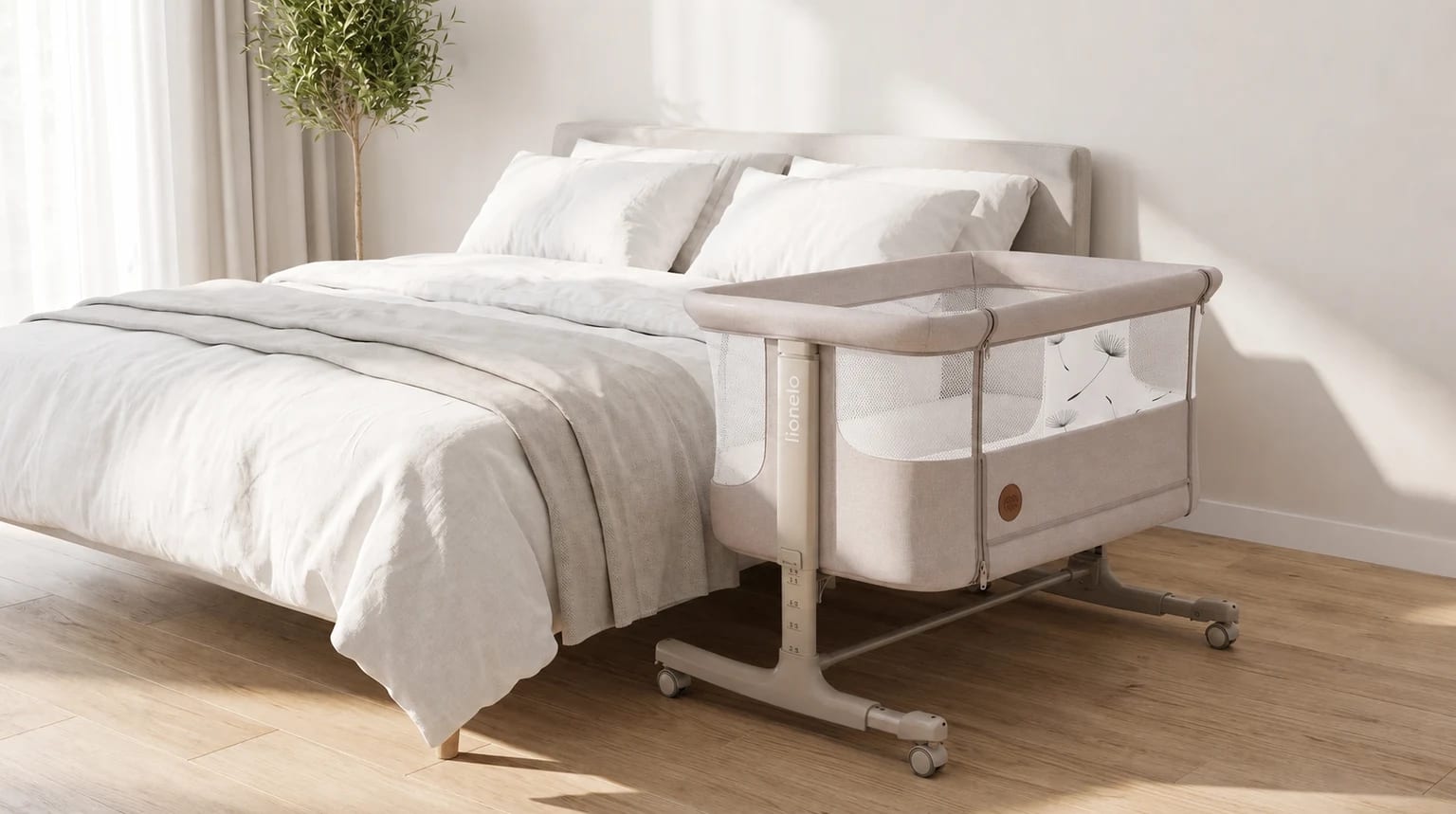 Minicuna de colecho beige junto a una cama en un dormitorio luminoso.