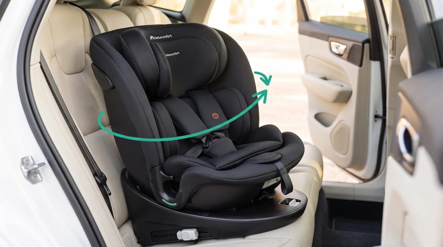 Silla de coche Bebeconfort RevolveFix 360 negra instalada en un coche, con una flecha verde que indica el giro.