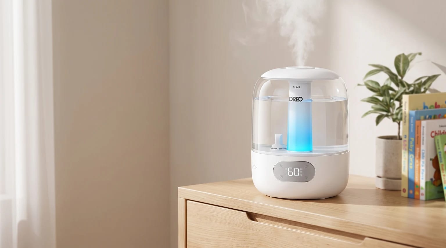 Un humidificador blanco con luz azul interna emite vapor sobre una cómoda de madera, al lado de una planta y libros infantiles.