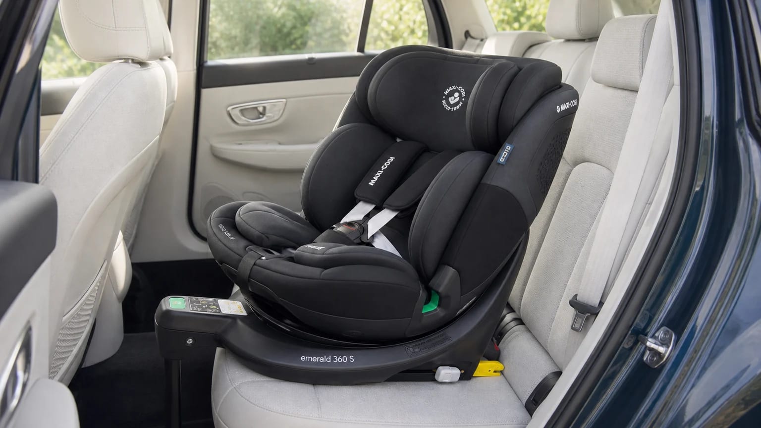 Silla de coche Maxi-Cosi Emerald 360 S negra instalada a contramarcha en el asiento trasero de un coche con tapicería clara.